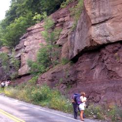 people standing by rock cliff
